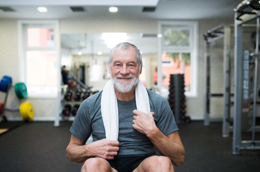 Oudere man kijkt gelukkig na het sporten