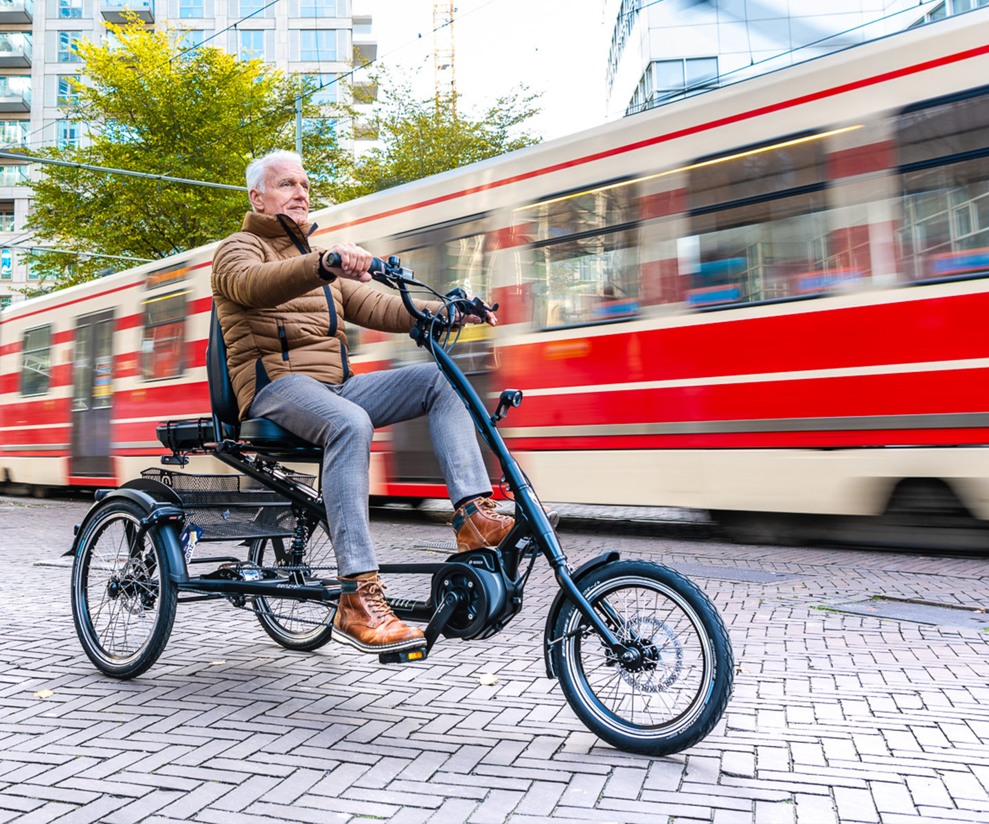 oudere man fiets op driewielfiets in stad naast tram