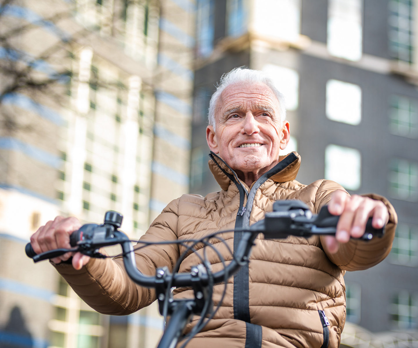 oude man fiets op driewielfiets en kijkt blij